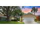 Charming single-Gathering home featuring a well-manicured lawn, mature trees, and an attached two-car garage at 11510 92Nd Way, Largo, FL 33773