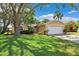 A beautiful home with a well-kept lawn, a mature tree, and a two-car garage at 11510 92Nd Way, Largo, FL 33773
