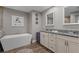 Modern bathroom featuring a soaking tub, double vanity, and wood-look floors at 12090 Thames Ave, Weeki Wachee, FL 34614