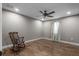 Comfortable bedroom showcasing hardwood floors, a ceiling fan, and a charming rocking chair at 12090 Thames Ave, Weeki Wachee, FL 34614