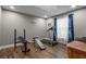 Bright exercise room with a treadmill, weight bench, and natural light, perfect for staying active at home at 12090 Thames Ave, Weeki Wachee, FL 34614