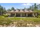 Daytime exterior view of a charming home with a front porch and well-maintained lawn at 12090 Thames Ave, Weeki Wachee, FL 34614