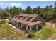 A partial aerial view of the house, with a covered front porch, accented with columns and porch swings at 12090 Thames Ave, Weeki Wachee, FL 34614