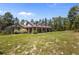 Charming single-story home featuring a welcoming front porch, lush lawn, and picturesque setting at 12090 Thames Ave, Weeki Wachee, FL 34614