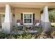 Inviting front porch featuring rocking chairs, fresh landscaping, and classic architectural details at 12090 Thames Ave, Weeki Wachee, FL 34614