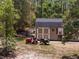 A charming shed accented by a lawn tractor and yard cart, shows rural home storage at its best at 12090 Thames Ave, Weeki Wachee, FL 34614