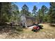 Well-maintained storage shed equipped with barn doors, fenced enclosure, and lawn care equipment at 12090 Thames Ave, Weeki Wachee, FL 34614