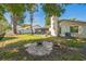 A lush backyard featuring a fire pit, mature trees, and ample space for outdoor enjoyment at 12838 Tallowood Dr, Riverview, FL 33579