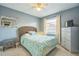 Cozy bedroom with a rattan headboard, light blue walls, and natural light from the window at 12838 Tallowood Dr, Riverview, FL 33579