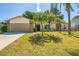 Charming home featuring stone accents, a well-maintained lawn, and decorative palm trees creating a welcoming curb appeal at 12838 Tallowood Dr, Riverview, FL 33579