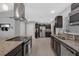 Spacious kitchen with stainless steel appliances, granite countertops, and modern vent hood at 12838 Tallowood Dr, Riverview, FL 33579