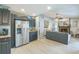 Open-concept living area with a fireplace, tile floors, and modern stainless steel refrigerator at 12838 Tallowood Dr, Riverview, FL 33579