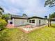 Backyard with brick paved patio next to manicured lawn and white exterior at 1290 Michigan Blvd, Dunedin, FL 34698