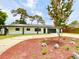 Charming single-story home with a circular driveway and freshly mulched landscaping at 1290 Michigan Blvd, Dunedin, FL 34698
