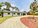Well-maintained home featuring a circular driveway and attractive landscaping at 1290 Michigan Blvd, Dunedin, FL 34698