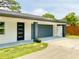 Attached garage with a modern door and an adjacent entrance to the home at 1290 Michigan Blvd, Dunedin, FL 34698