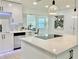 Contemporary kitchen with stainless steel appliances, white cabinets, and a sleek island cooktop at 1290 Michigan Blvd, Dunedin, FL 34698