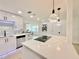 Bright kitchen with stainless steel appliances, island cooktop, and white cabinets offers modern design and functionality at 1290 Michigan Blvd, Dunedin, FL 34698