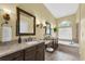 Bright bathroom featuring double sink vanity, granite countertops, large mirrors, and luxurious soaking tub at 137 Woodcreek E Dr, Safety Harbor, FL 34695