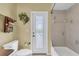 Bathroom featuring a toilet, a tub/shower combination and a decorative wreath on the door at 137 Woodcreek E Dr, Safety Harbor, FL 34695
