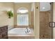 Bathroom featuring a large soaking tub with tile surround and a separate shower with glass door at 137 Woodcreek E Dr, Safety Harbor, FL 34695