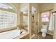 Bright bathroom featuring a soaking tub, a walk-in shower with glass door and a toilet at 137 Woodcreek E Dr, Safety Harbor, FL 34695
