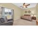 Cozy bedroom featuring a ceiling fan, window with blinds, and neutral décor at 137 Woodcreek E Dr, Safety Harbor, FL 34695