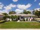 Beautiful home exterior with a well-manicured lawn, vibrant landscaping, and elegant architectural details at 137 Woodcreek E Dr, Safety Harbor, FL 34695