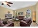 Comfortable living room features arched windows, ceiling fan, and plush leather seating at 137 Woodcreek E Dr, Safety Harbor, FL 34695