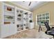 Bright office boasts custom built-in shelving, storage, and a sun-filled window for a comfortable work environment at 137 Woodcreek E Dr, Safety Harbor, FL 34695