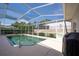 Private screened-in pool area with lush landscaping and serene backyard views, ideal for relaxation and recreation at 137 Woodcreek E Dr, Safety Harbor, FL 34695