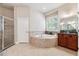 Bright bathroom with a corner jacuzzi tub, tiled floors and a glass shower at 16039 Ternglade Dr, Lithia, FL 33547