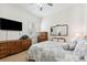 Comfortable bedroom with a ceiling fan, dresser, a wall-mounted TV, and neutral decor at 16039 Ternglade Dr, Lithia, FL 33547