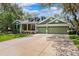 Inviting home featuring an attractive green exterior, well-manicured lawn, and a spacious three-car garage at 16039 Ternglade Dr, Lithia, FL 33547
