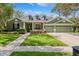 Charming one-story home featuring a three-car garage, well-manicured lawn, and attractive landscaping at 16039 Ternglade Dr, Lithia, FL 33547