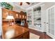 Home office featuring wood paneled walls, built-in shelving and cabinet storage at 16039 Ternglade Dr, Lithia, FL 33547