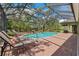Relaxing screened-in pool with lounge chairs and brick patio, perfect for outdoor living at 16039 Ternglade Dr, Lithia, FL 33547