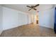 This bedroom features neutral tile flooring, a ceiling fan, and spacious closet at 1648 Concord St, Dunedin, FL 34698