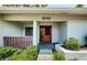 Close-up of the home's entryway with a decorative red door and tiled porch at 1648 Concord St, Dunedin, FL 34698