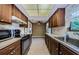 Kitchen featuring wood cabinets, a white backsplash, and black appliances at 1648 Concord St, Dunedin, FL 34698
