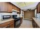 Well-lit kitchen featuring wood cabinets, white backsplash, and black oven at 1648 Concord St, Dunedin, FL 34698