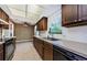 Kitchen showcasing wood cabinets, white backsplash, stainless steel sink and black appliances at 1648 Concord St, Dunedin, FL 34698