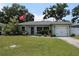 Single-story home featuring a well-maintained lawn and an attached garage at 1665 Grove St, Clearwater, FL 33755
