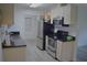 This well-lit kitchen features stainless steel appliances, light cabinets and black countertops at 1665 Grove St, Clearwater, FL 33755