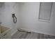 A utility sink with laundry hook-ups are featured in this home's laundry room with neutral paint and modern vinyl flooring at 1665 Grove St, Clearwater, FL 33755