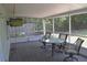 Enjoy outdoor living on this screened patio with stone floors, a TV, and a glass table with four chairs at 1665 Grove St, Clearwater, FL 33755
