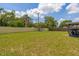 Spacious fenced backyard with lush greenery, a playset, and a covered patio offering a private outdoor space at 1720 Fruitridge St, Brandon, FL 33510