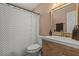Updated bathroom with a patterned shower curtain, wood-look vanity with a framed mirror, and modern fixtures at 1720 Fruitridge St, Brandon, FL 33510