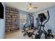 Home exercise room with work out equipment, a mounted television, and built-in shelving filled with media at 1720 Fruitridge St, Brandon, FL 33510