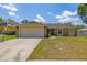 Charming single-story home showcasing a manicured lawn, a driveway, and an attached two-car garage at 1720 Fruitridge St, Brandon, FL 33510